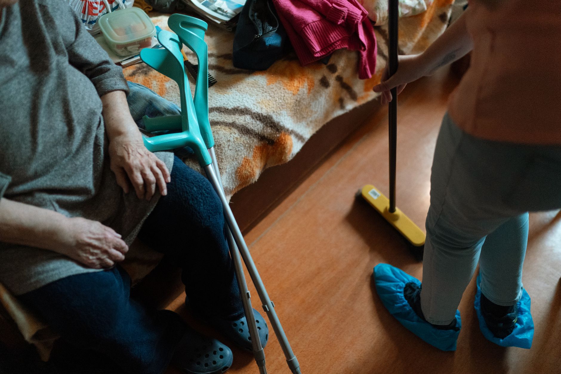 Une aide à domicile accompagne une personne âgée dans sa cuisine