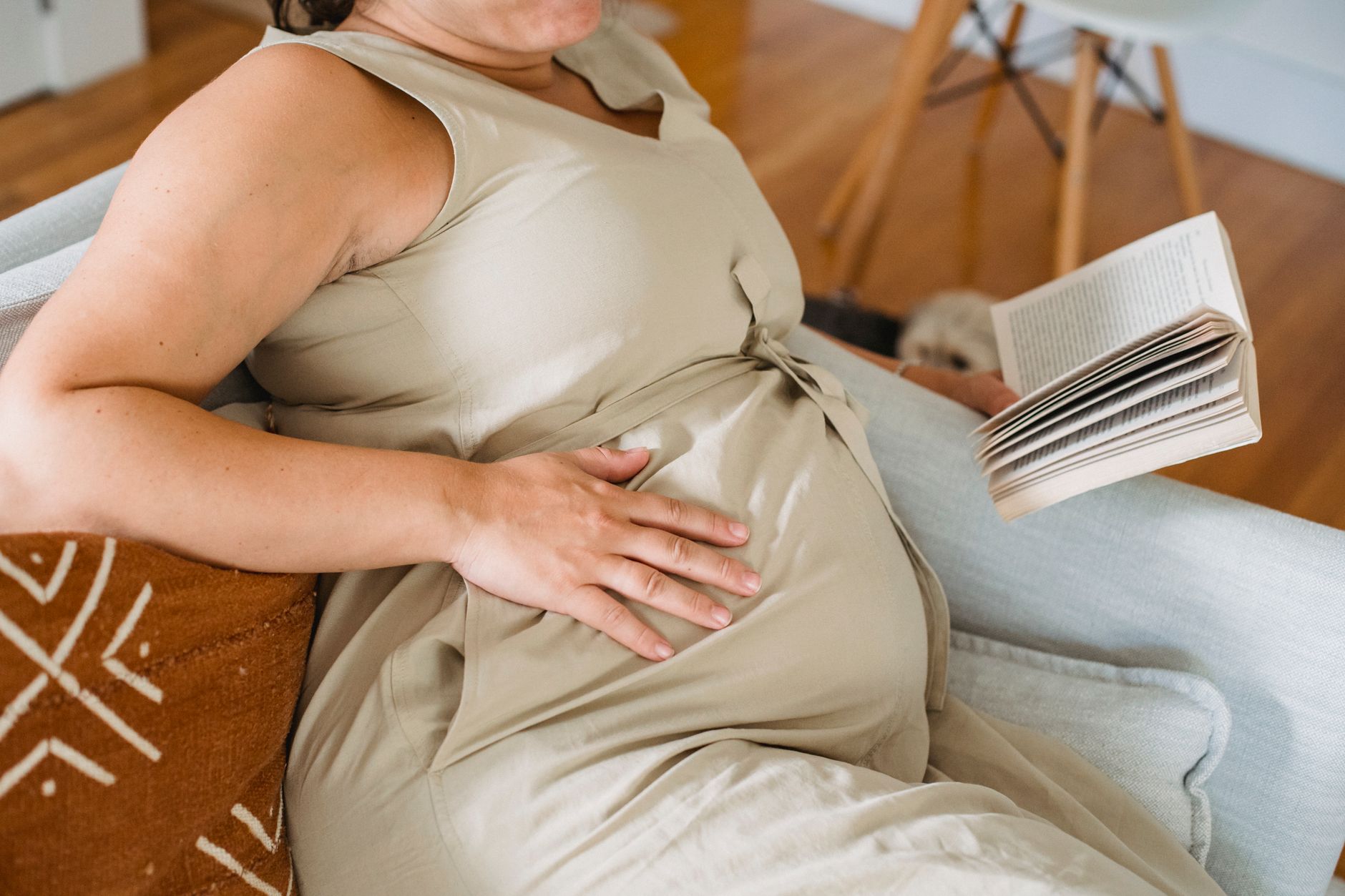 Une femme enceinte assise chez elle, calendrier de grossesse en main